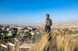 © almostfuture - Girl tourist looks at the horizon in Göreme, Cappadoci. Tourist town with houses in Cappadocia.