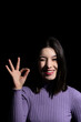 © larrui - brunette woman doing the ok symbol winking an eye on black background