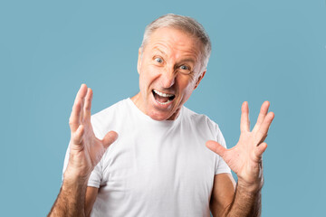 Portrait of angry mature man screaming at studio