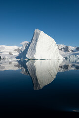 Wall Mural - Ice berg reflected in calm water in the Errera Channel in Antarctica