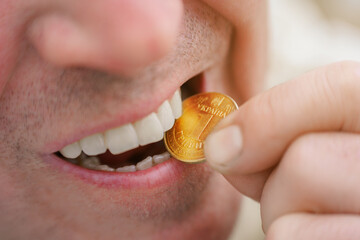 A man bites a Ukrainian 1 hryvnia coin to check its authenticity