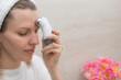 woman using microcurrent facial toning device at home. Modern beauty skincare concept. cropped image