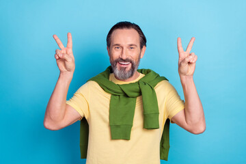 Poster - Portrait of candid satisfied man two arms demonstrate v-sign beaming smile isolated on blue color background