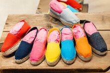 Multicolored Canvas Espadrilles Placed On Wooden Shelf In Showroom