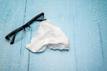 Wall Mural - Top view of reading glasses with black temples and glasses cleaning cloth on light blue lacquered wooden surface