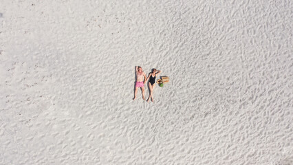 Aerial view of a young couple lying on the white sand. man and woman spend time together and travel through the desert