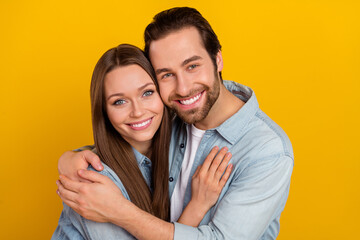 Poster - Photo of cheerful positive boyfriend girlfriend dressed denim shirts embracing smiling isolated yellow color background