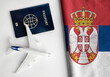 Flag of Serbia with passport and toy airplane. Flight travel concept
