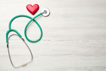 Wall Mural - Stethoscope and red heart on white wooden table, flat lay with space for text. Cardiology concept