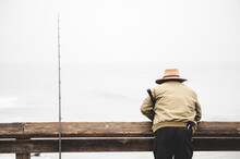 Man From Behind Fishing, Standing On A Pier With A Rod