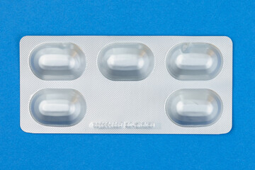 Wall Mural - Blister or pack of five tablets or pills. The concept of five working days. Dark blue background.