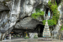 Statue Of Virgin Mary In The Grotto Of Our Lady Of Lourdes, France - French Famous Catholic Pilgrimage Destination