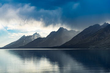 Canvas Print - Reflective lake and rocky mountains in Grand Teton National park under the gloomy sky in Wyoming