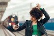 © Zamrznuti tonovi - Woman waiting on a train station platform and using smartphone