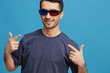 © SHOTPRIME STUDIO - Cheerful man in blue t-shirt 3d glasses entertainment gesture with hands isolated background