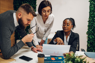 Wall Mural - Multicultural team working together in office and having a meeting