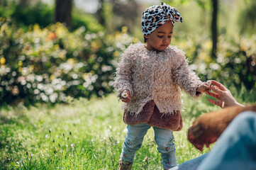 Wall Mural - Little african american girl smiling and playing in the park