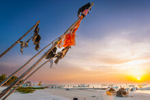 Flags Fly Over Boats On Holbox Beach In Mexico's Yucatan Peninsula At Sunset