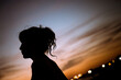 female silhouette against the evening town horizon