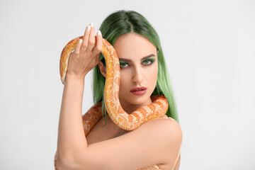 Sticker - Portrait of sexy young woman with green hair and snake on light background