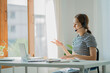 © ArLawKa - Young Asian student wearing headphones using a laptop Write a note about learning a language. View webinars online. audio listening course e-learning concept