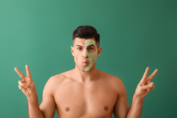 Sticker - Handsome man with bubble mask showing victory gesture on green background