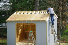 worker building the shed in the back yard
