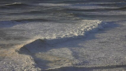 Poster - Large foamy wave rolling on the surface of a stormy ocean at sunset, 4k