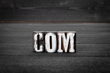 Canvas Print - COM. Domain name concept. Word from wooden blocks on a dark background