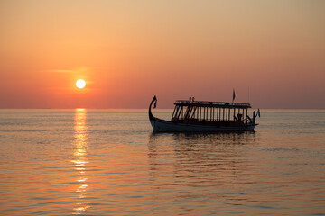 Tourist Boat on Horizon Line at Sunset in the Maldives