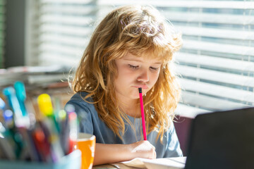Fototapete - Preteen serious schoolboy doing her homework at home. Child study. Education and learning for kids. Cute little boy doing homework in classroom.