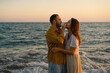 © Анастасія Стягайло - Young romantic couple dancing turning around by sea. Seascape at sunset with beautiful sky. Romantic couple on the beach at golden sunset. Lover couple having fun on beach.