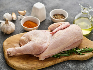 half raw chicken, ingredients for cooking, garlic, vegetables on wooden rustic board, uncooked chick