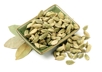 Wall Mural - Green cardamom pods and Aromatic bay leaves on white background