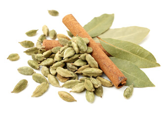Wall Mural - Green cardamom pods,cinnamon and aromatic bay leaves on white background