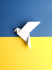Wall Mural - Peace symbol with an origami dove on blue and yellow paper