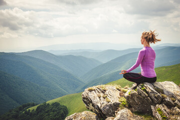 Young woman on the top of mountain