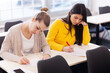 © Nikola Spasenoski - Students taking a test in a classroom. Smart young girls study at a college.
