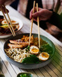 Japanese ramen soup with chicken, egg, chives, spinach, and bacon.