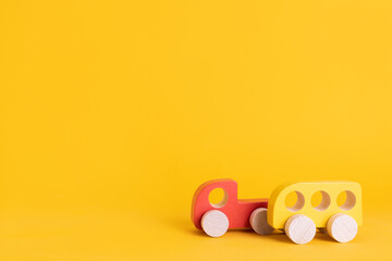 Wall Mural - Wooden toy car in cartoon style on yellow background. Colorful and Transportation background, eco kid toys Montessori . 