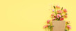 Leinwandbild Motiv Top view image of pink flowers composition over yellow background