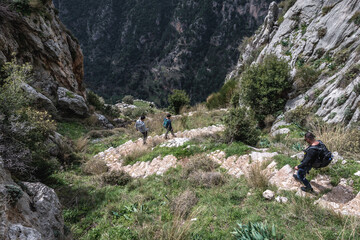 Canvas Print - Tourists on a path from Hawka village to Kadisha Valley in North Governorate region, Lebanon