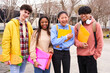 © CarlosBarquero - Confident multiracial group of students holding books and smiling at camera, campus university on background, learning and education concept. Smiling happy young people having fun together