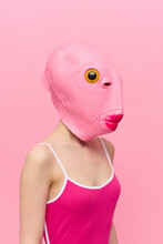 Funny Crazy Woman On A Pink Background Standing In A Fish Head Mask On A Pink Background, Conceptual Halloween Costume Art Photo