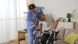 © PRPicturesProduction - asia female nursing aide helping injured retired male to use a walker while he is slowly standing up from the couch at home. in-home health care for elderly senior concept