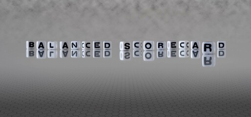 Sticker - balanced scorecard word or concept represented by black and white letter cubes on a grey horizon background stretching to infinity