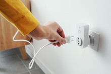 Woman plugging a device into a smart plug