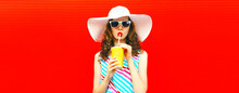 Portrait Of Beautiful Young Woman Drinking Fresh Juice Wearing Summer Hat On Red Background