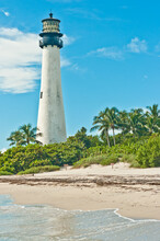 Front View, Far Distance Of A, Functioning,  Tropical, Tall, White, Brick, Lighthouse, Surrounded With Vegitation