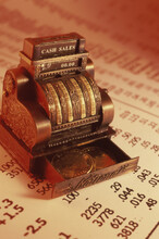 Close-up Of A Miniature Cash Register Machine On Stock Listings